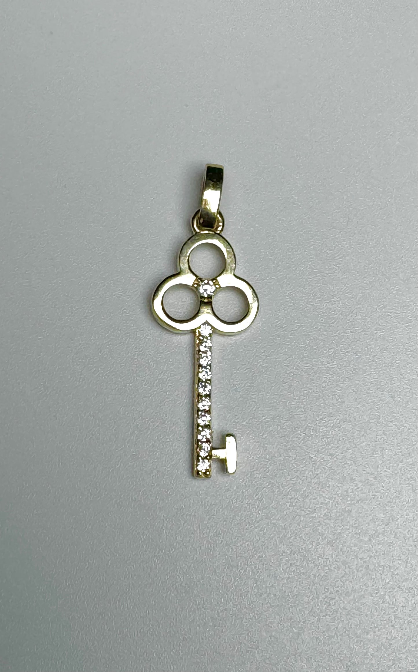 Gold key pendant with zircon