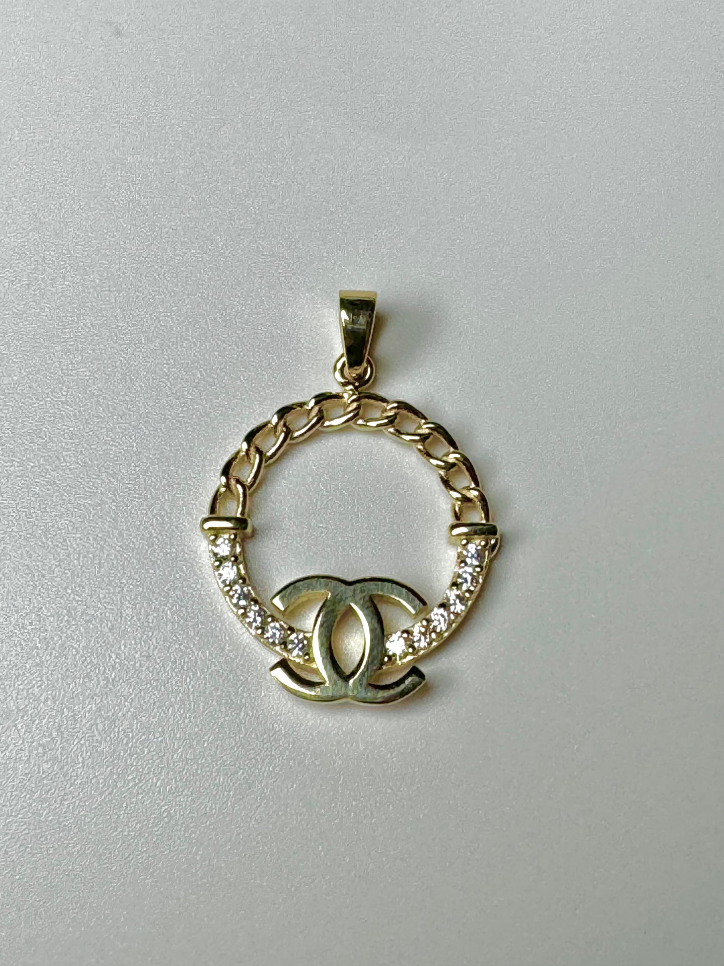 Gold pendant with letter CC and zircon