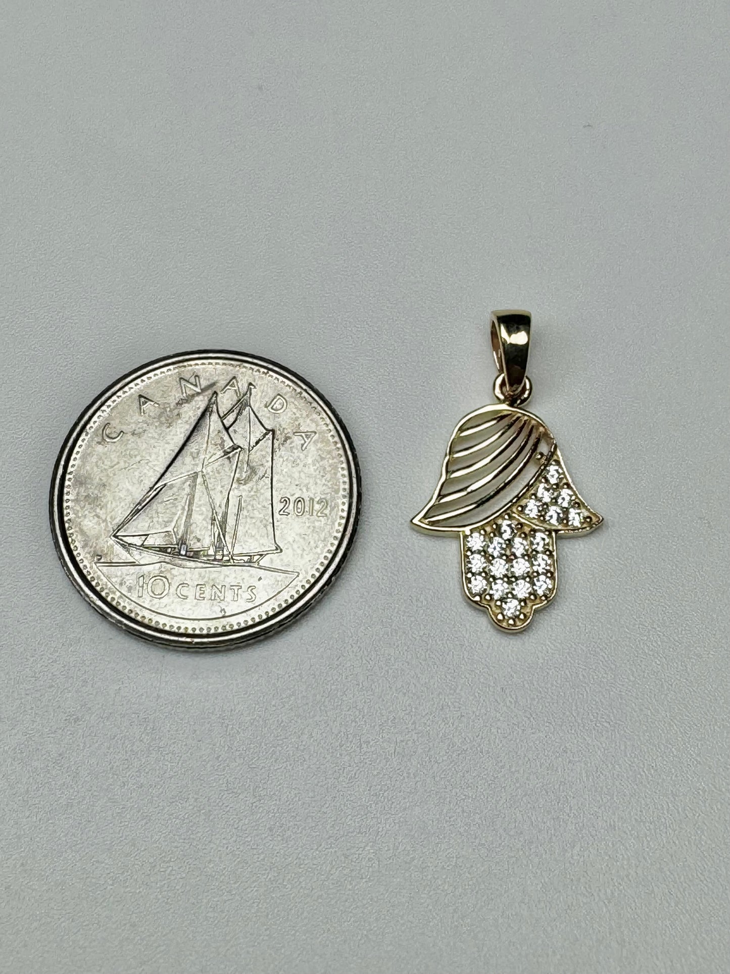 Gold Fatima hand pendant with zircon