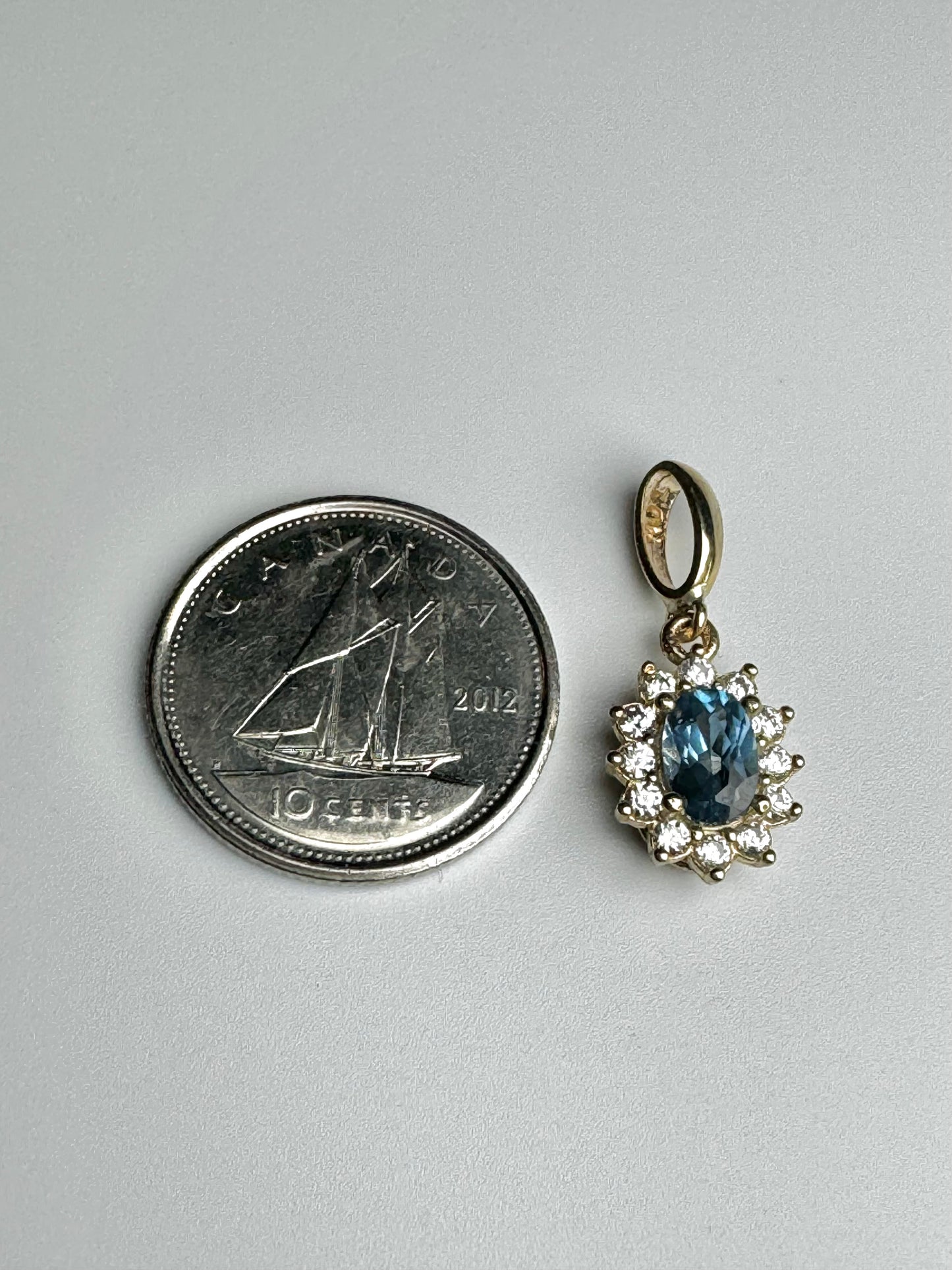 Oval gold pendant with aquamarine and white zircon￼