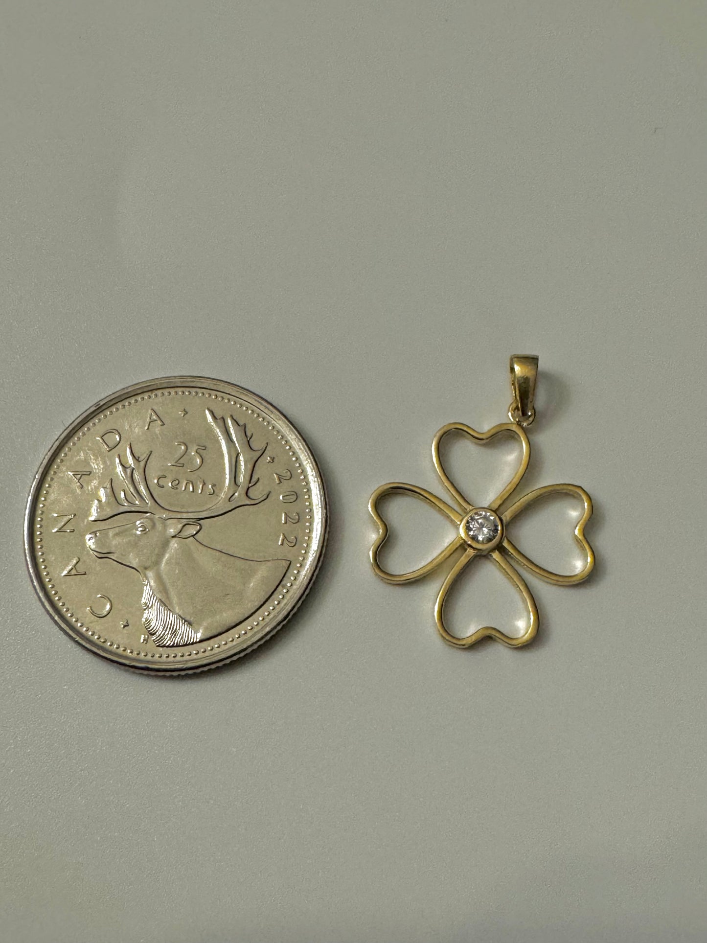 Gold clover pendant with zircon in the center