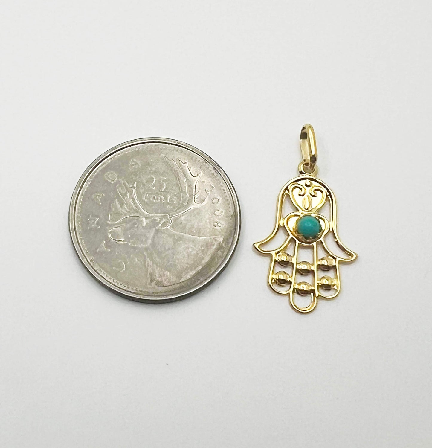 Gold Fatima hand pendant with green zircon